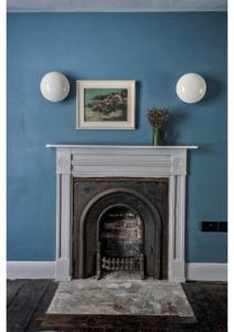 a blue wall with a fireplace in a room at House in Hastings in Hastings