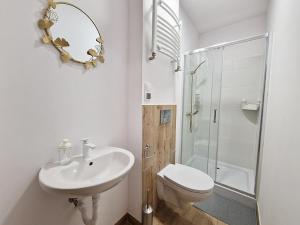 a bathroom with a sink and a toilet and a mirror at Noclegi Kielce - Dom nad rzeką - pokoje in Kielce