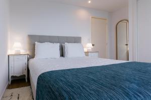 a bedroom with a large bed with a blue blanket at Fatima`s House in Funchal