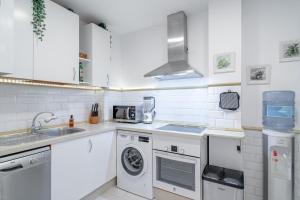 a white kitchen with a sink and a dishwasher at Home Away From Home Marbella in Marbella