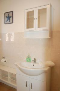 a bathroom with a sink and a cabinet at Ann's Beach House in Tywyn in Tywyn