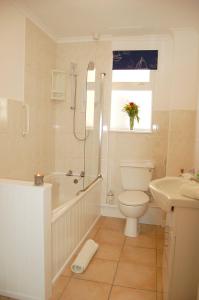 a bathroom with a toilet and a tub and a sink at Ann's Beach House in Tywyn in Tywyn