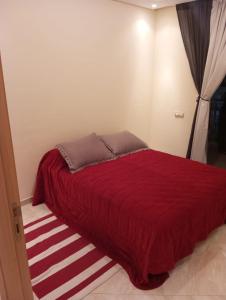- une chambre avec un lit rouge et une couverture rouge dans l'établissement Chems Bouznika, à Bouznika