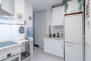 a kitchen with white cabinets and a refrigerator at Home Away From Home Marbella in Marbella