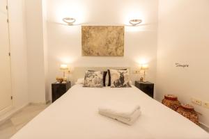 una camera da letto con un grande letto bianco con due lampade di San Eloy Sevilla by TheGoodTourist a Siviglia