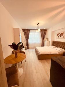 a bedroom with a bed and a table in a room at Sudului ApartHotel in Bucharest +54 photos