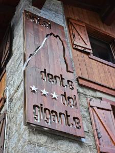 una señal en el lateral de un edificio en Hotel Dente Del Gigante, en Courmayeur