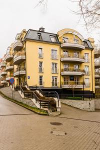 a large yellow building with stairs in front of it at Apartament Bulwary Łyna przy Starym Mieście in Olsztyn