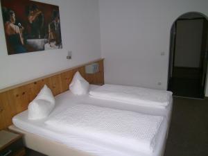 two beds in a room with white sheets at Gasthof Hotel Kirchenwirt in Zell am Ziller