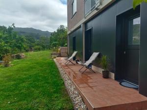 2 chaises assises sur une terrasse à côté d'un bâtiment dans l'établissement Albergue O Corisco, à Redondela