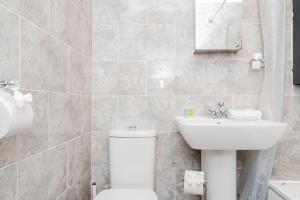 Cozy 1-Bedroom Flat at Abingdon في أوكسفورد: حمام به مرحاض أبيض ومغسلة