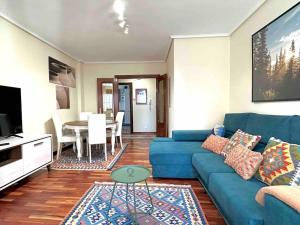 a living room with a blue couch and a table at Apartamento en el casco antiguo in Castro-Urdiales