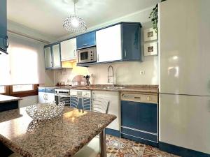 a kitchen with blue cabinets and a counter top at Apartamento en el casco antiguo in Castro-Urdiales +19 photos