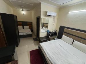 a small bedroom with two beds and a mirror at Hotel Himgiri in Jammu