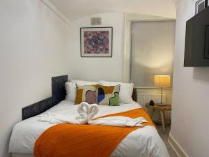 1 dormitorio con 1 cama con manta naranja en Central Point apartment en Londres