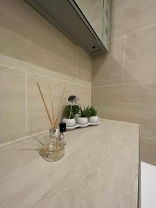 a counter with three potted plants on it in a bathroom at Central Point apartment in London