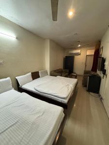 賈姆穆的住宿－Hotel Himgiri，一间客房配有两张床和一张沙发
