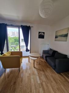 a living room with a couch and a table at Appartement neuf avec balcon/ fibre/parking privé in Massy