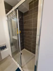 a shower with a glass door in a bathroom at Appartement neuf avec balcon/ fibre/parking privé in Massy