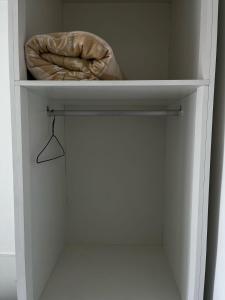 a white closet with a bed and a towel at Hotel Delavy in Chapecó