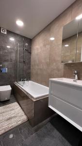 uma casa de banho com uma banheira, um lavatório e um WC. em Modern Apartment in Kings Cross em Londres