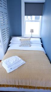 a blue bedroom with a bed with a window at Ideal location! Studio flat in heart of the city in Bristol