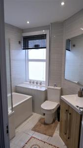 a bathroom with a toilet and a tub and a sink at Ideal location! Studio flat in heart of the city in Bristol