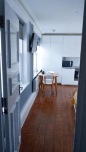 a room with a table and a kitchen with white cabinets at Ideal location! Studio flat in heart of the city in Bristol