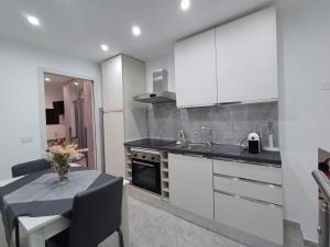a kitchen with white cabinets and a table and a sink at Casa ITRIA 15 in Agrigento