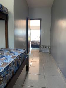 1 dormitorio con cama, ventana y silla en ZZZCK CASAS PRIVATIVAS 2 DORM AR WIFI VAGAS COZINHa, en Itapema