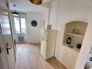 a kitchen with a white refrigerator in a room at Appartement centre ville in Le Blanc