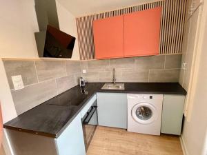 a kitchen with a washing machine and a sink at Appartement centre ville in Le Blanc