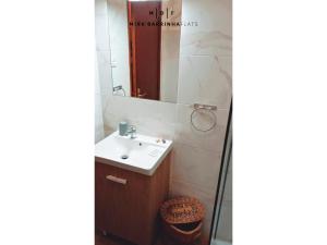 a bathroom with a sink and a mirror at Mira'Barrinha Flats in Praia de Mira