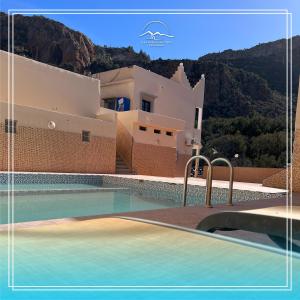 eine Villa mit einem Pool vor einem Haus in der Unterkunft Hotel Amalou in Agadir