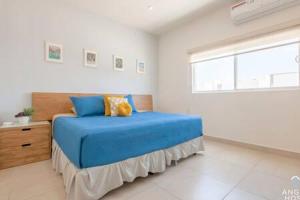 a bedroom with a blue bed and a window at Spacious home with private yard and community pool in La Paz