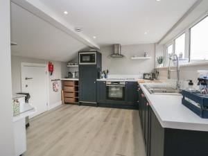 a kitchen with green cabinets and white counter tops at Helton Fell in Kendal