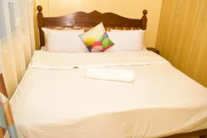 a bed with white sheets and a towel on it at Fully furnished two bedroom bnb in Thika town in Thika