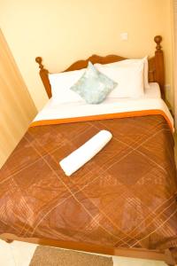 a bed with a wooden head board with a white pillow at Fully furnished two bedroom bnb in Thika town in Thika