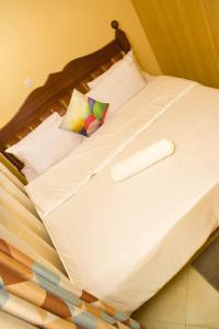 a bed with white sheets and pillows at Fully furnished two bedroom bnb in Thika town in Thika