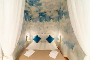 a bedroom with a blue and white painting on the wall at Rezident in Bucharest