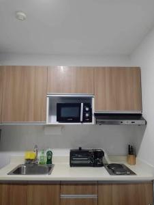 een keuken met een wastafel en een magnetron bij Uptown Condo Primavera Residences in Cagayan de Oro