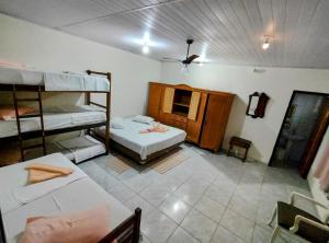 a room with two bunk beds and a tv at Suítes Corais in Ubatuba