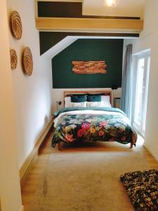 1 dormitorio con cama y pared verde en Maya sweet rooms en Heerlen