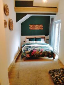 um quarto com uma cama e uma parede verde em Maya sweet rooms em Heerlen