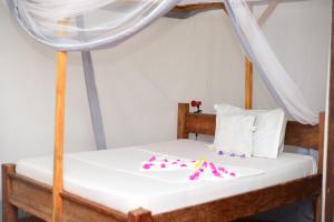 a bed in a room with a canopy bed at Furaha Lodge in Jambiani