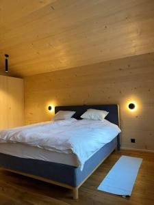 een slaapkamer met een groot bed en een houten plafond bij Penthouse at The Bären 180º View in Zweisimmen