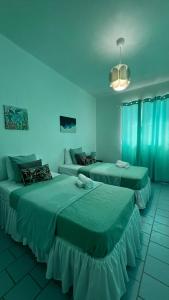 two beds in a room with blue lighting at Villa Alborada in Arecibo