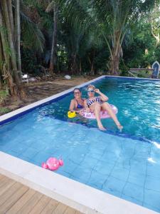 Dos mujeres están sentadas en una piscina en Chacara Santa Barbara, en Manaus