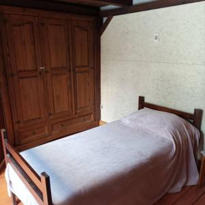 ホセ・イグナシオにあるDe improvisoのベッドルーム1室(ベッド1台付)、木製キャビネットが備わります。