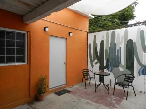 un patio avec une table et des chaises à côté d'un mur avec du cactus dans l'établissement KayackHouse, à San Carlos